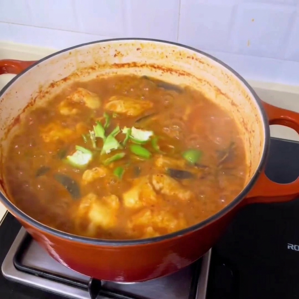 Rondelles de piment vert frais parsemées sur la riche soupe de palourdes bouillonnante à la coréenne.