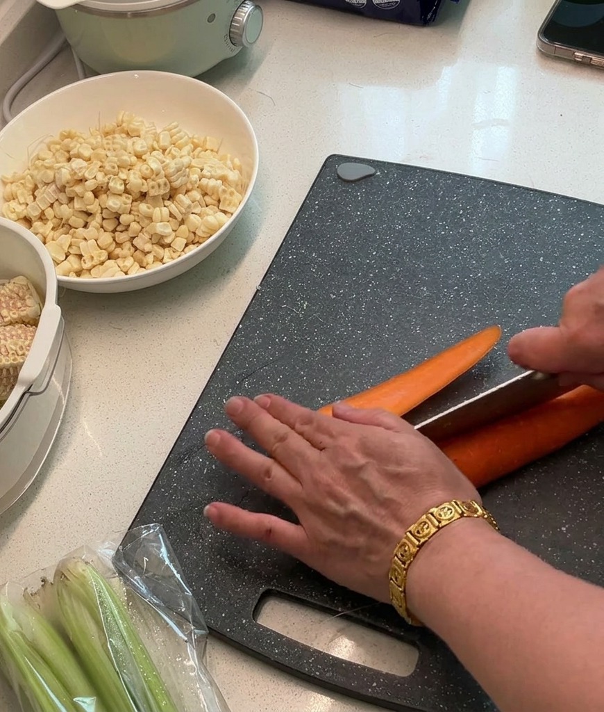 Des carottes fraîches coupées en petits dés réguliers sur une planche à découper foncée.