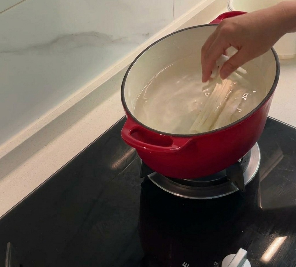 Les barbes de maïs, les rafles et les peaux de poulet frémissent dans une grande marmite deau pour créer un bouillon savoureux.
