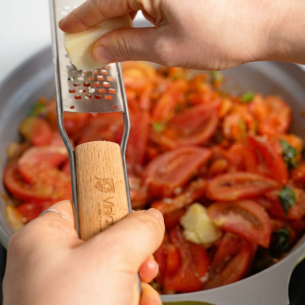 Du parmesan frais râpé sur une sauce à la viande copieuse et bouillonnante dans une poêle.