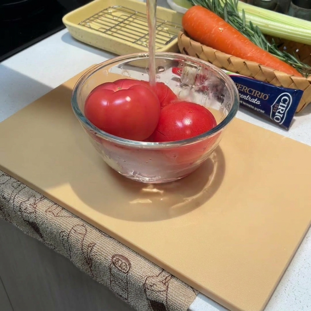 Gros plan sur des tomates entières dans un bol que lon recouvre deau chaude.