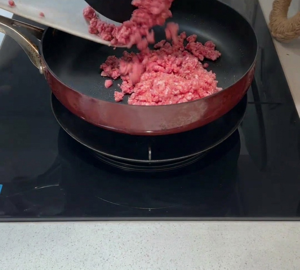 De la viande hachée crue ajoutée dans une poêle chaude avec un peu dhuile.