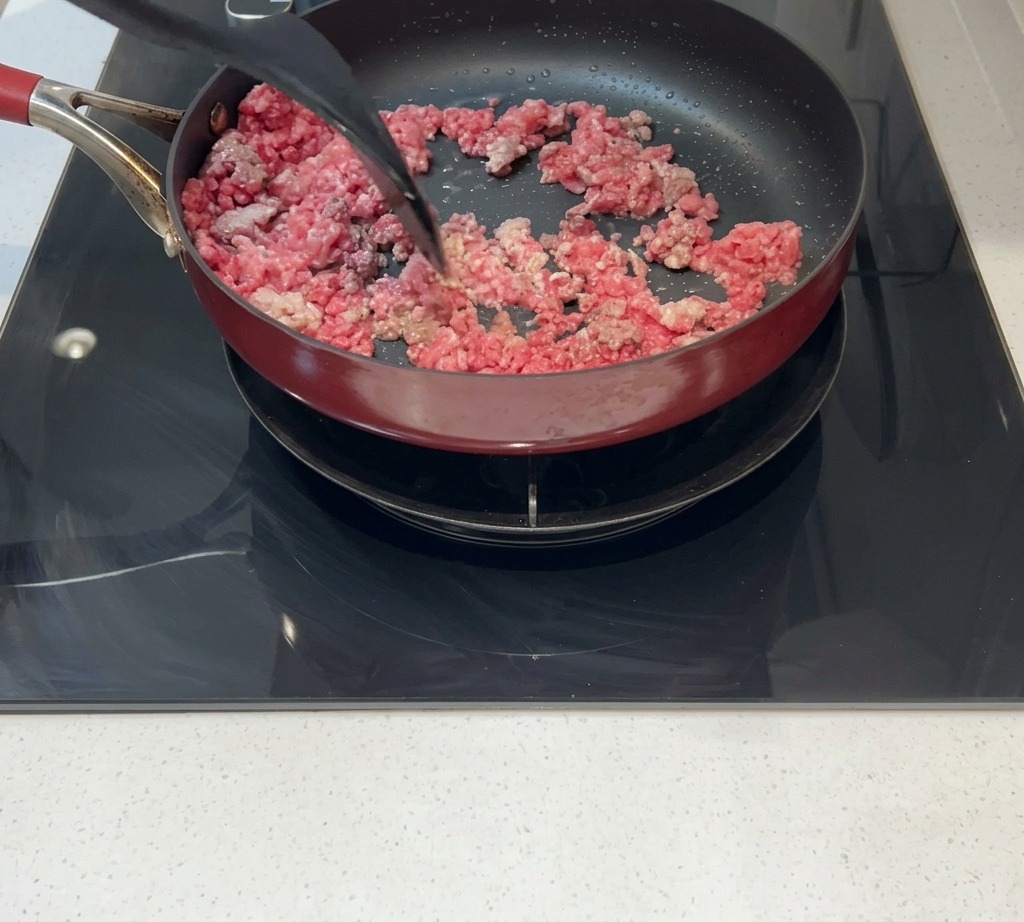De la viande hachée remuée dans une poêle jusquà ce quelle soit dorée et entièrement cuite.