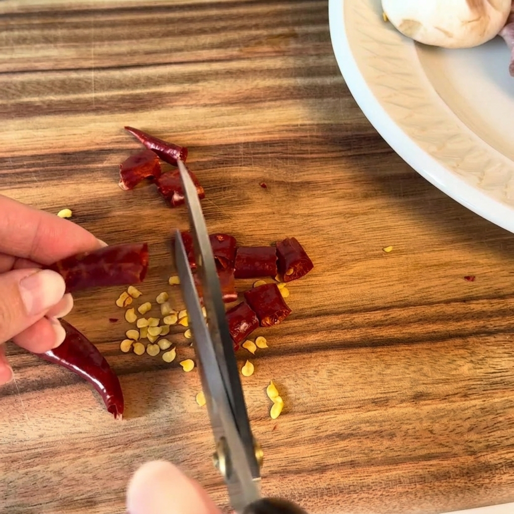 Piments séchés coupés en petits morceaux avec des ciseaux de cuisine.