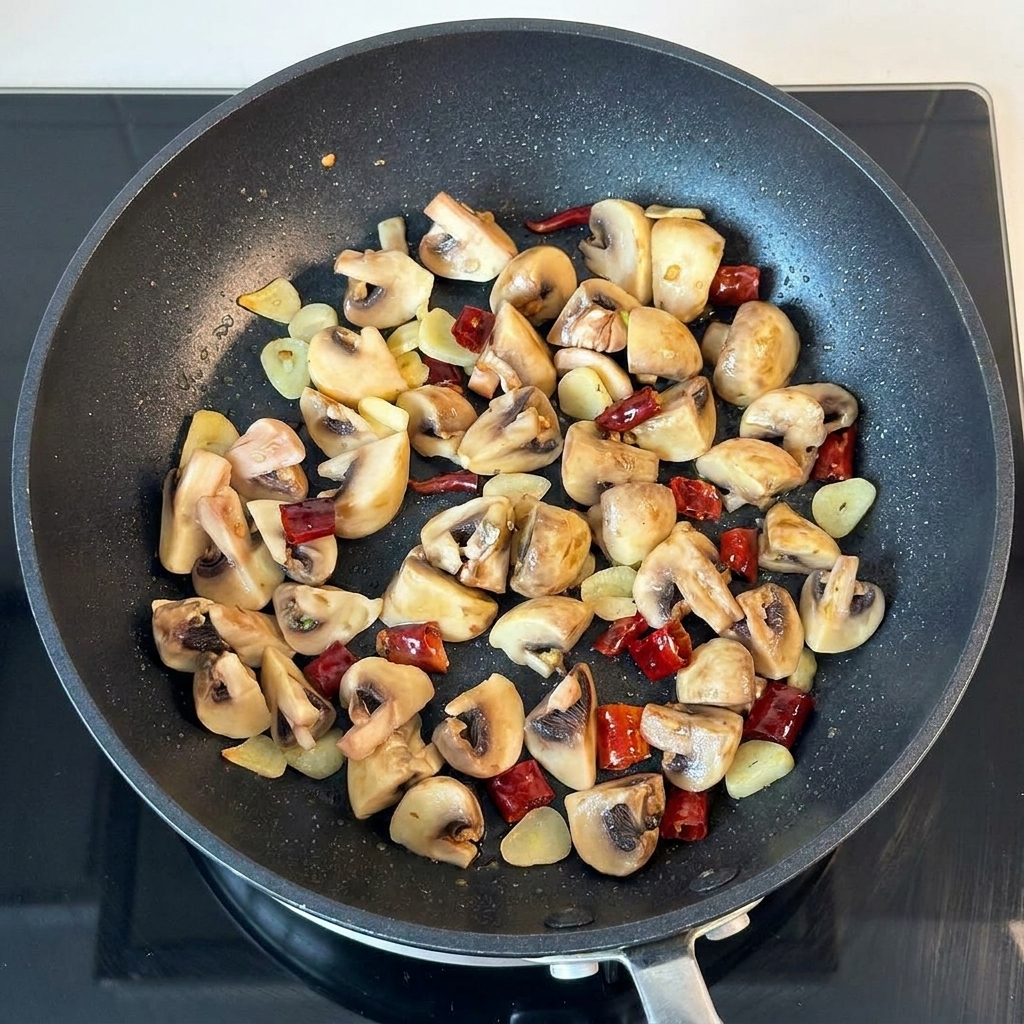 Beurre et persil séché ajoutés à la poêle de champignons sautés.