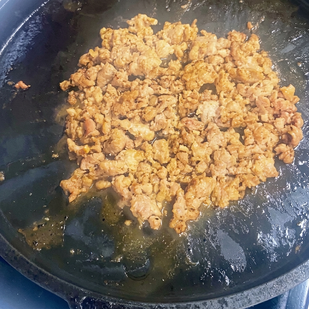 Bœuf haché en train de dorer dans une poêle en fonte chaude.