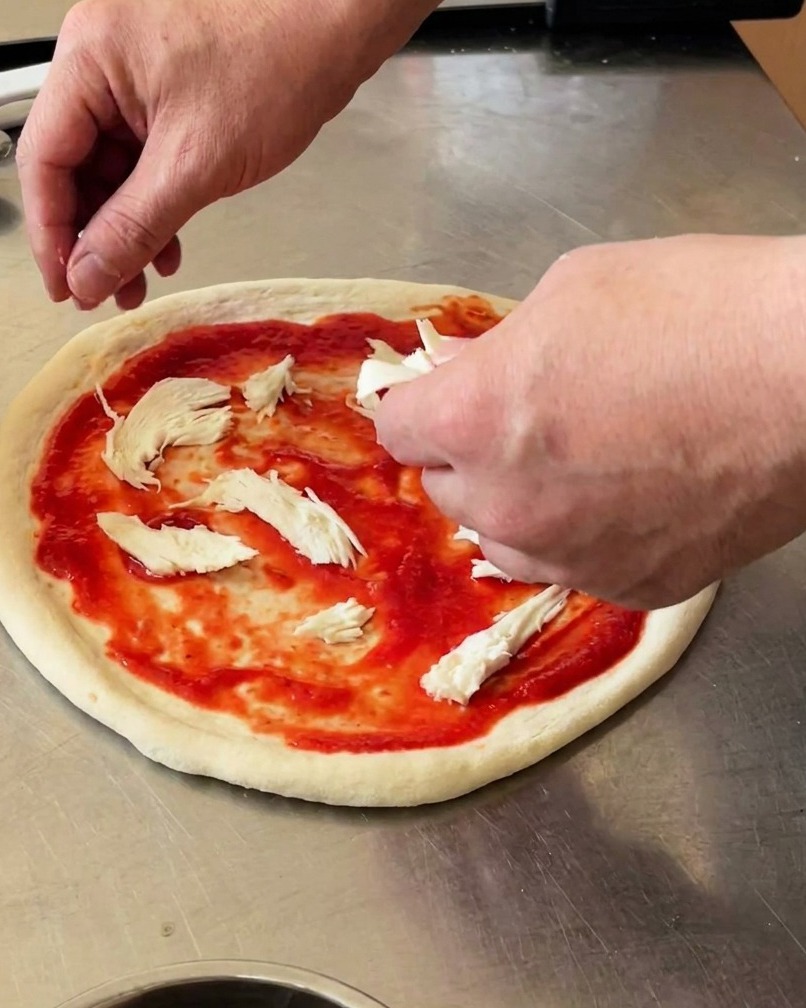Pizza garnie de morceaux de mozzarella di bufala et de basilic frais.