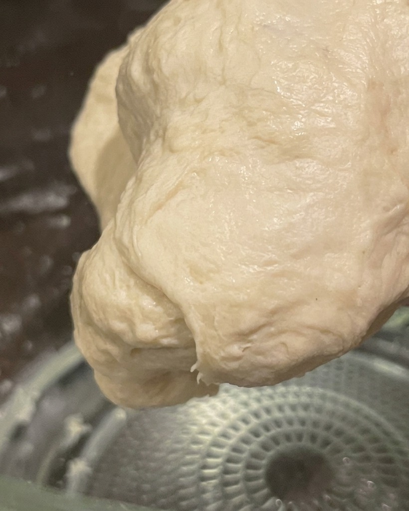 Une boule de pâte lisse et élastique, pétrie à la main et prête pour la fermentation.