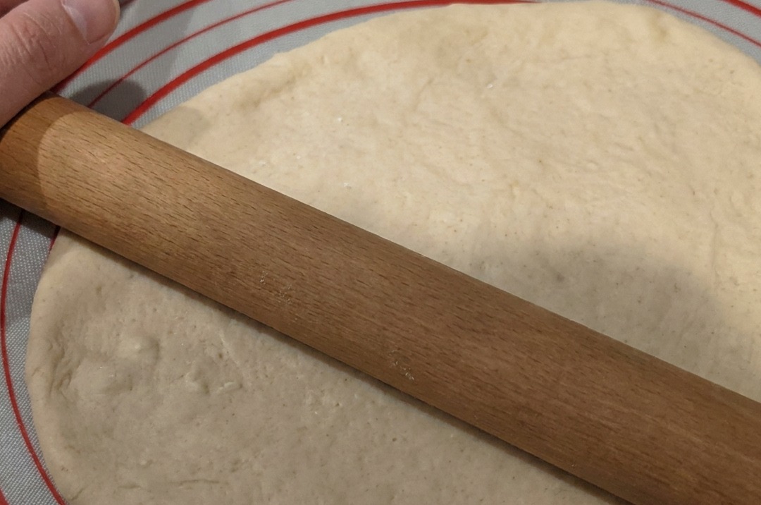 La pâte est étalée en un cercle plat sur un tapis en silicone antiadhésif.