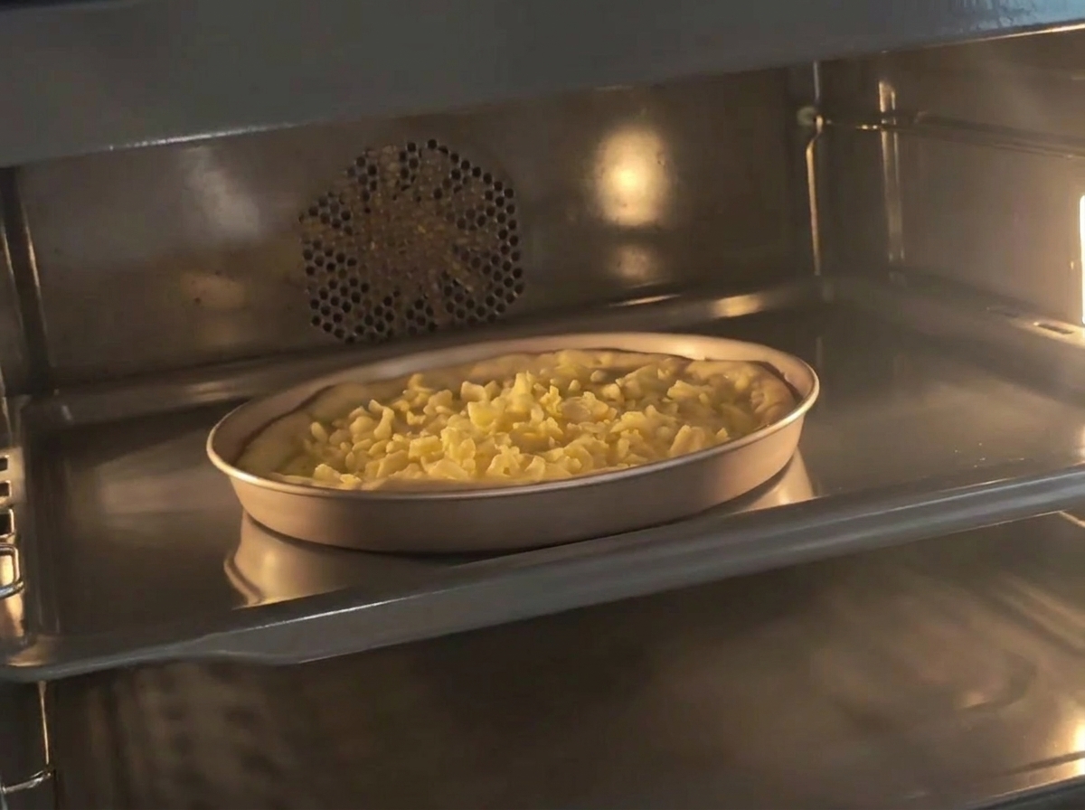 Le moule avec la pâte préparée et le fromage au four préchauffé.