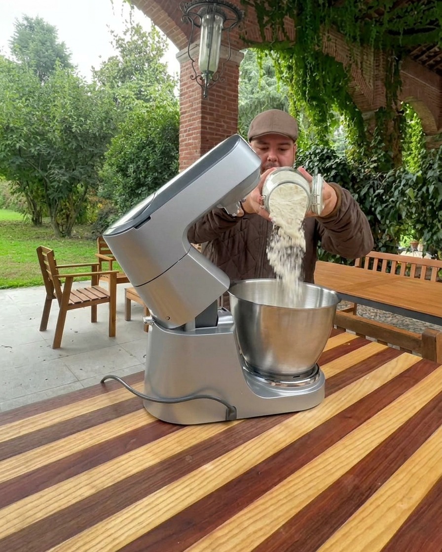 Farine versée dans le bol dun grand robot culinaire en acier inoxydable.