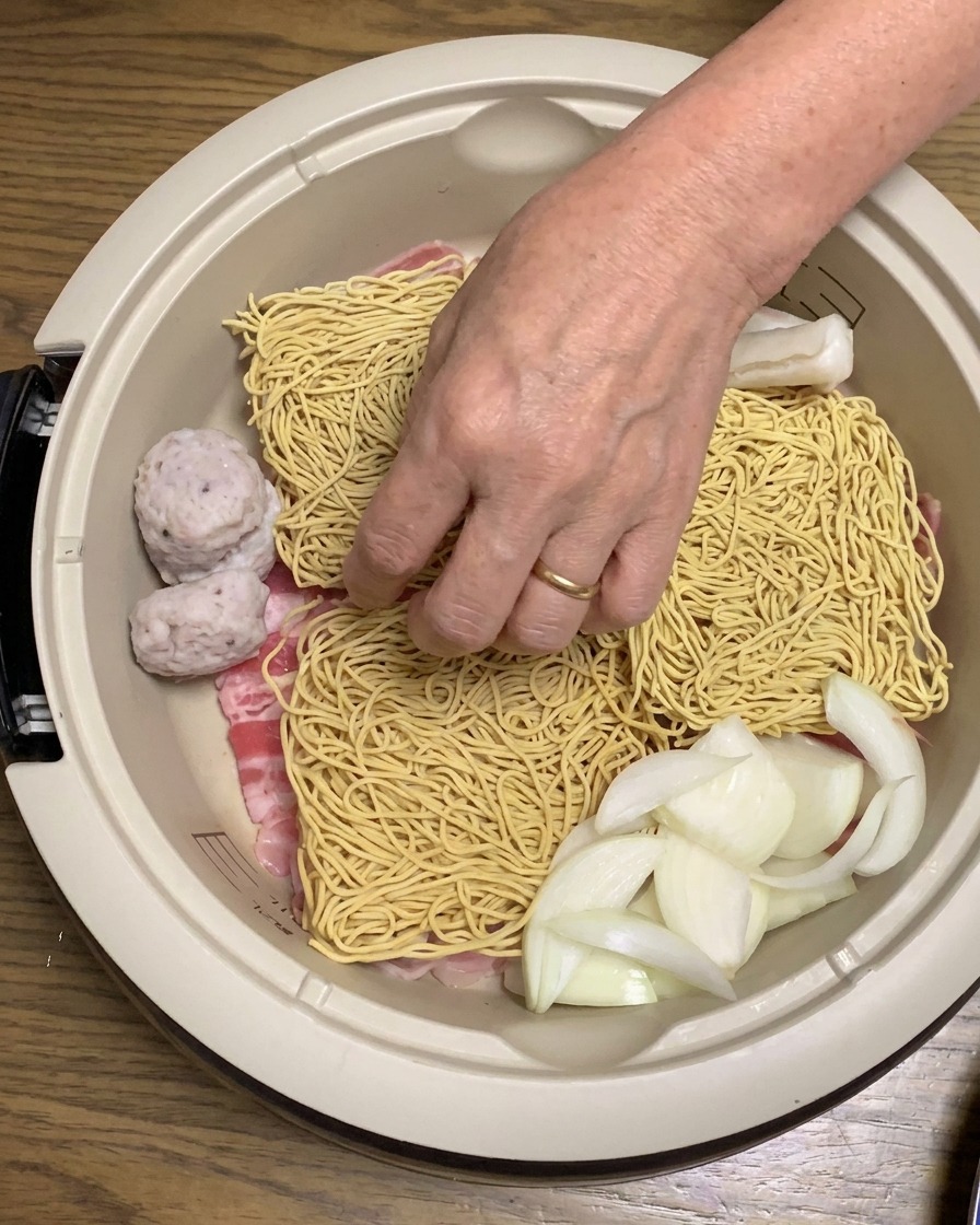 Gâteaux de riz et tofu frit doré ajoutés aux ingrédients dans la casserole.
