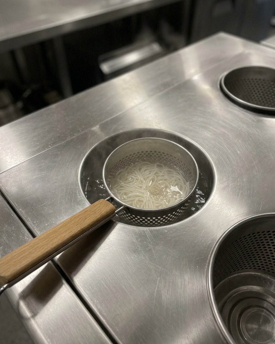 Des nouilles ramen cuites dans un bol de service, prêtes pour lajout du bouillon chaud.