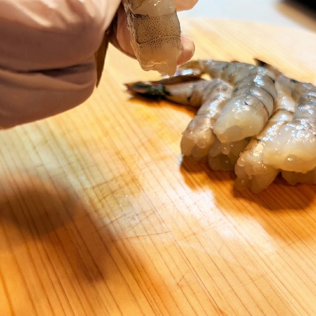 Crevettes entaillées et redressées avec un couteau.