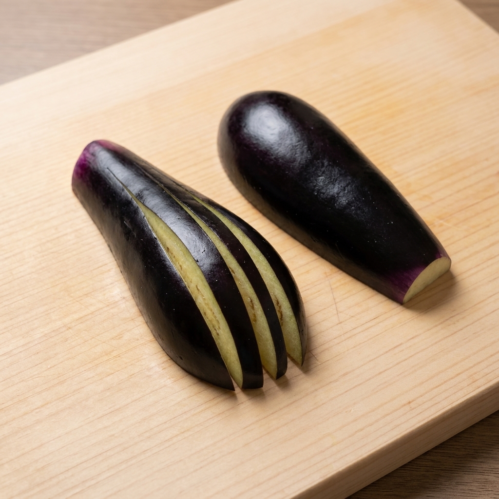 Aubergine coupée en éventail sur une planche à découper.
