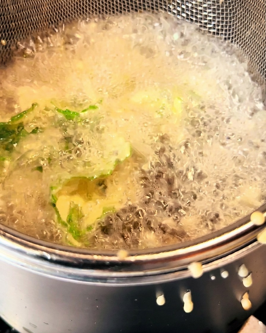 Légumes verts en pâte en train de frire dans lhuile chaude, dorés et croustillants.
