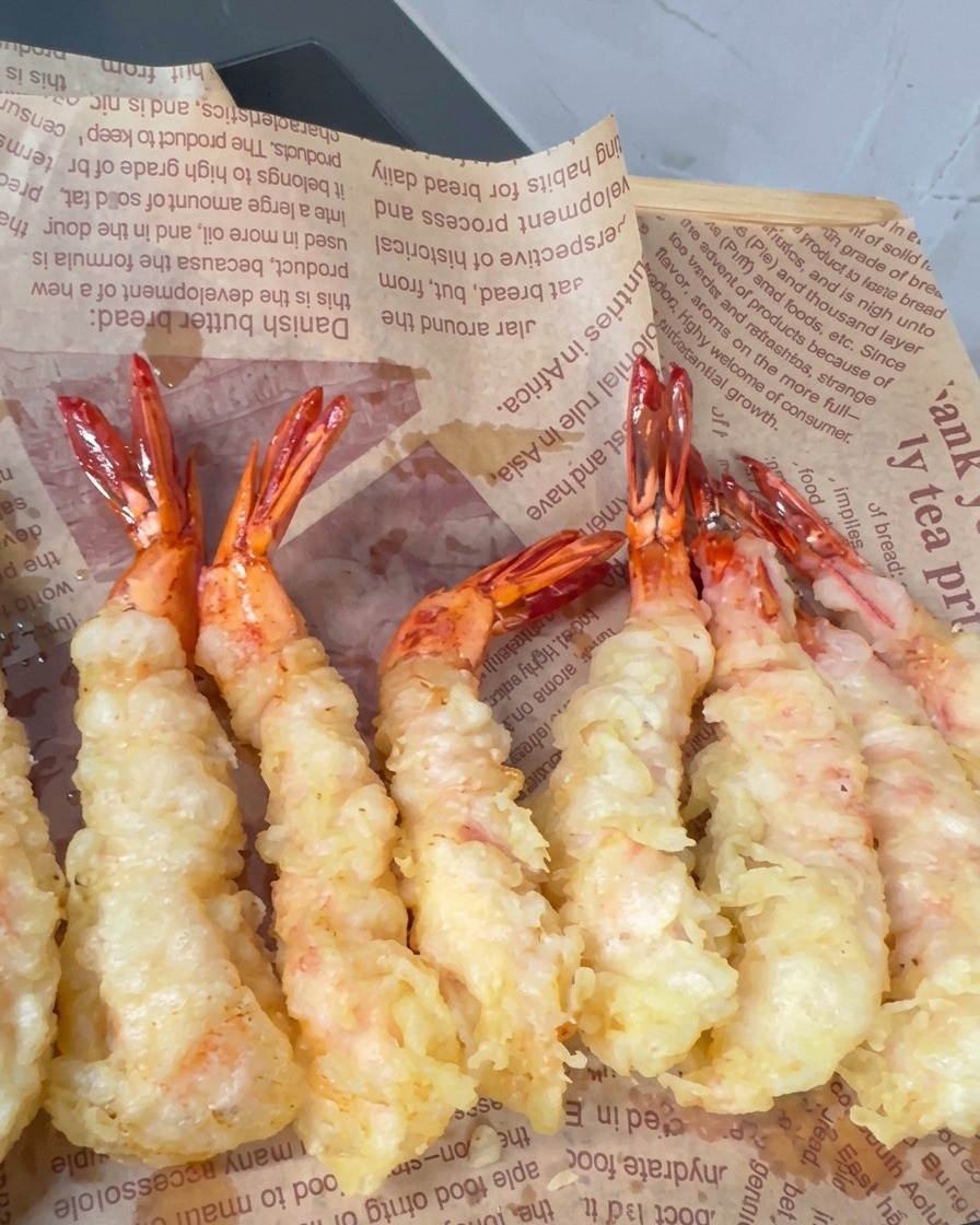 Crevettes panées en friture avec des pointes croustillantes se formant en surface.