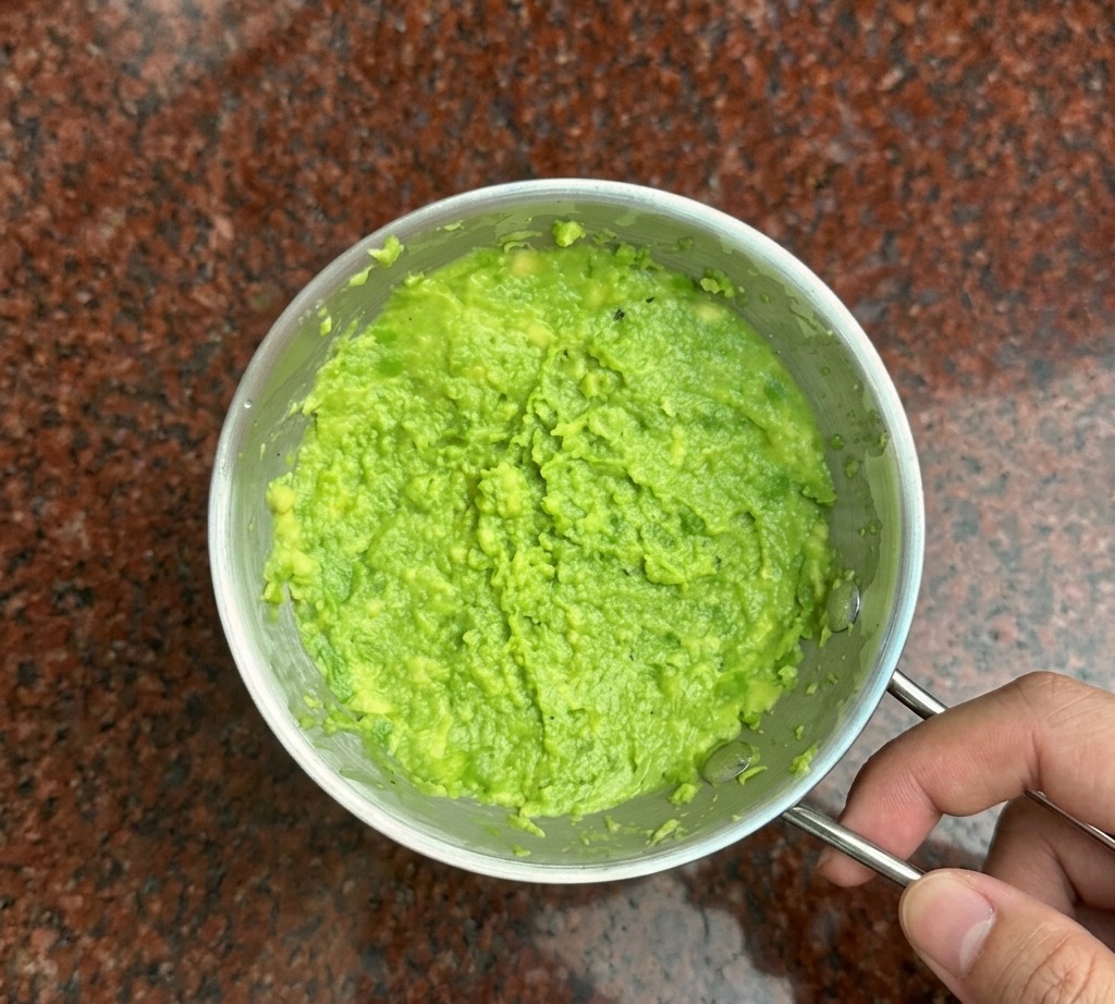 Une fourchette en métal écrasant de lavocat bien vert dans un petit bol.