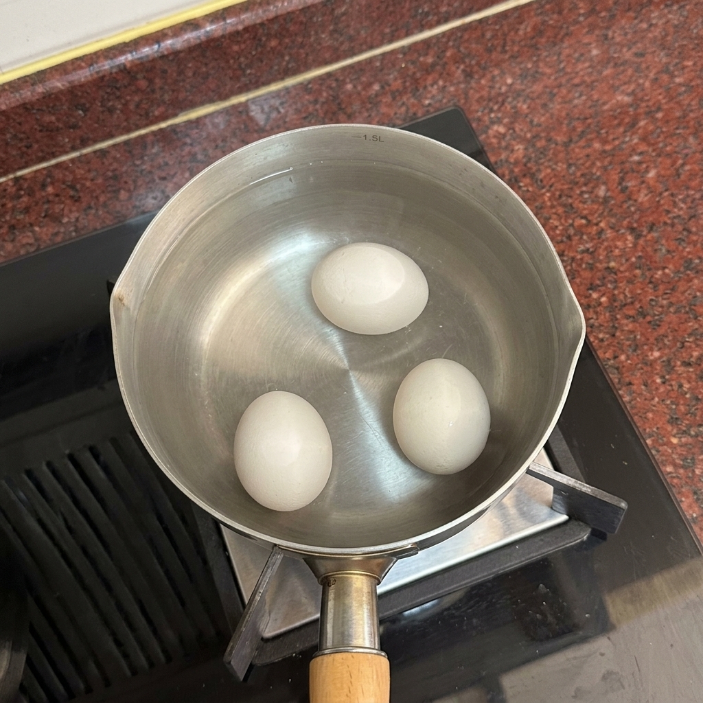 Deux œufs entiers reposant au fond dune casserole remplie deau chaude.