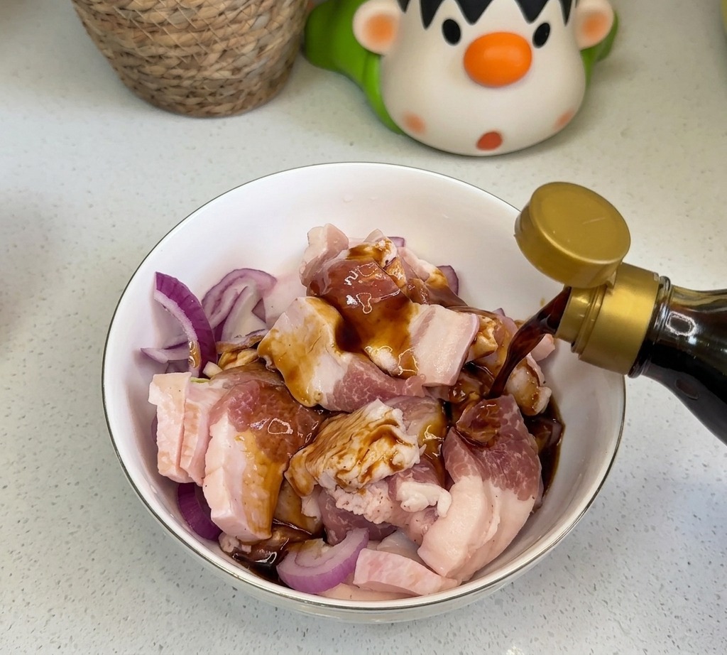 Des sauces liquides foncées comme la sauce soja et la sauce dhuître versées sur le porc et les oignons.