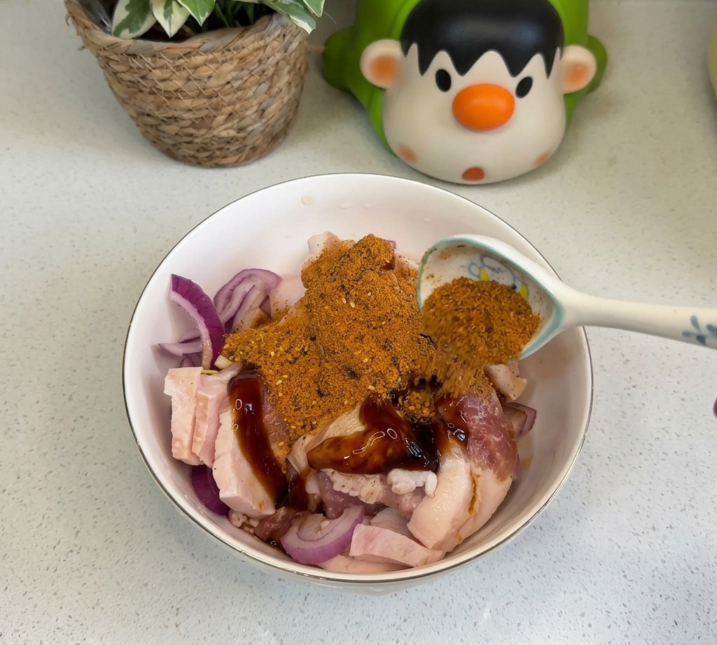 Une cuillère dépices barbecue orange et de piment rouge en poudre saupoudrée sur la viande.