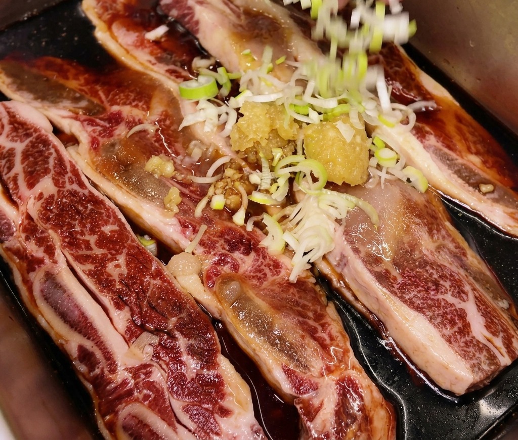 Oignons verts émincés parsemés à la main sur un plateau de travers de bœuf crus déjà assaisonnés dail et de gingembre.