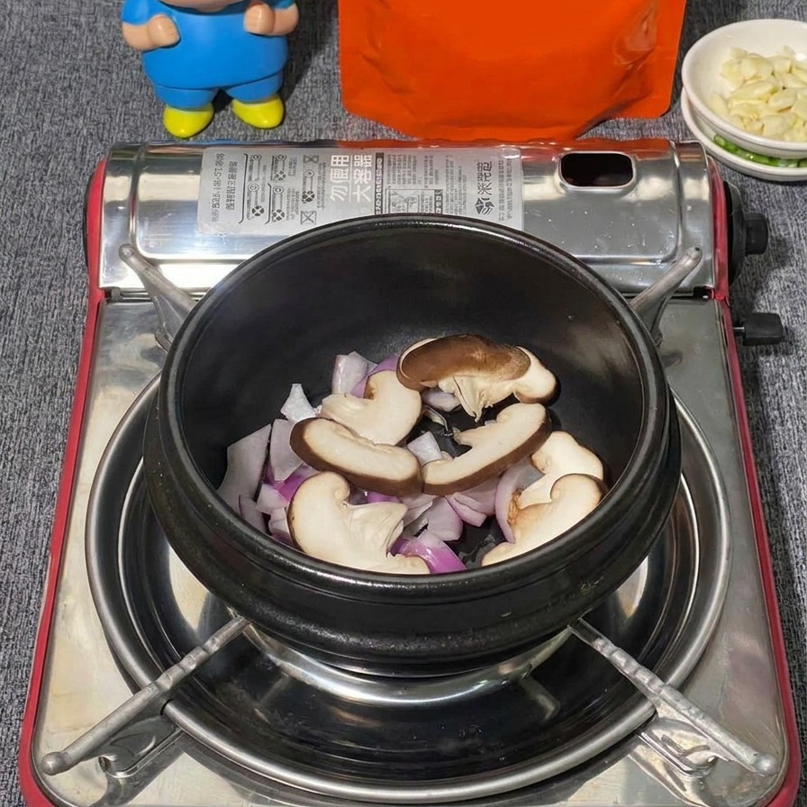 Une variété de champignons, dont des shiitakes émincés et des grappes de shimeji blancs, disposés sur des oignons rouges dans un pot en pierre noir.