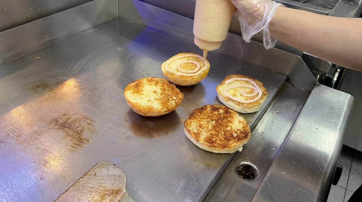 Sauce onctueuse appliquée en spirale sur des pains briochés toastés.