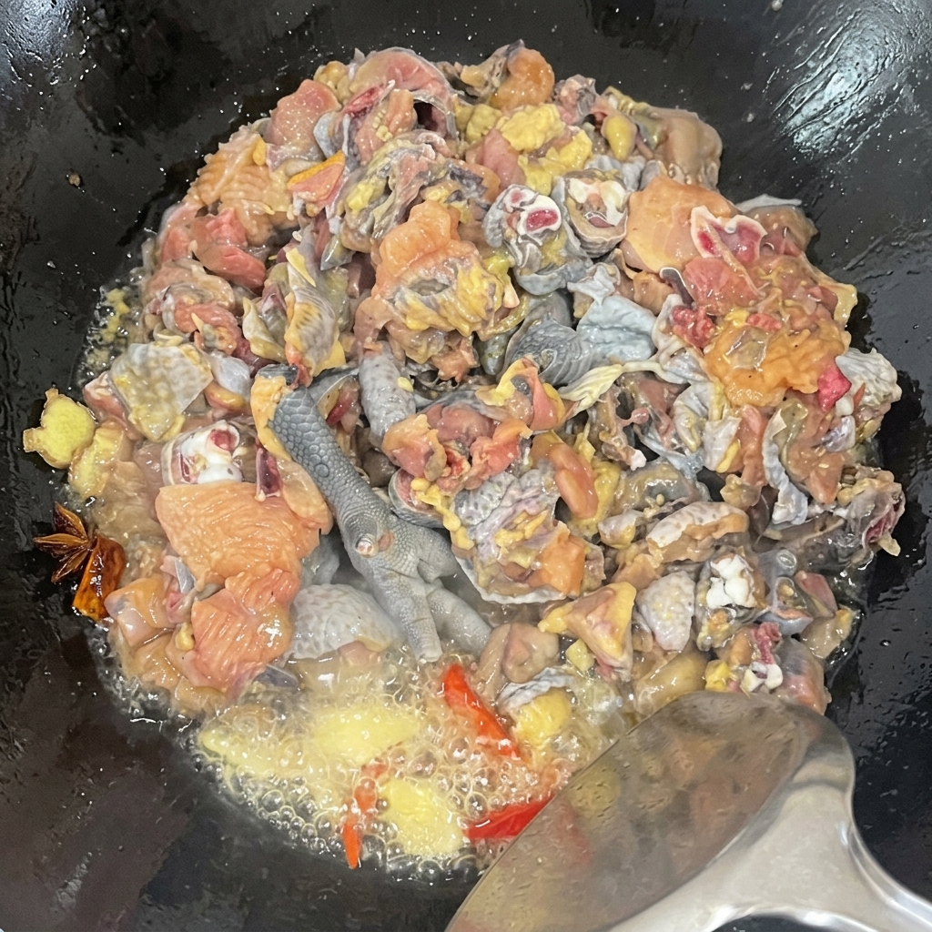 Gros plan sur des morceaux de poulet de soie sautés dans un wok avec des épices au milieu de lhuile frémissante.