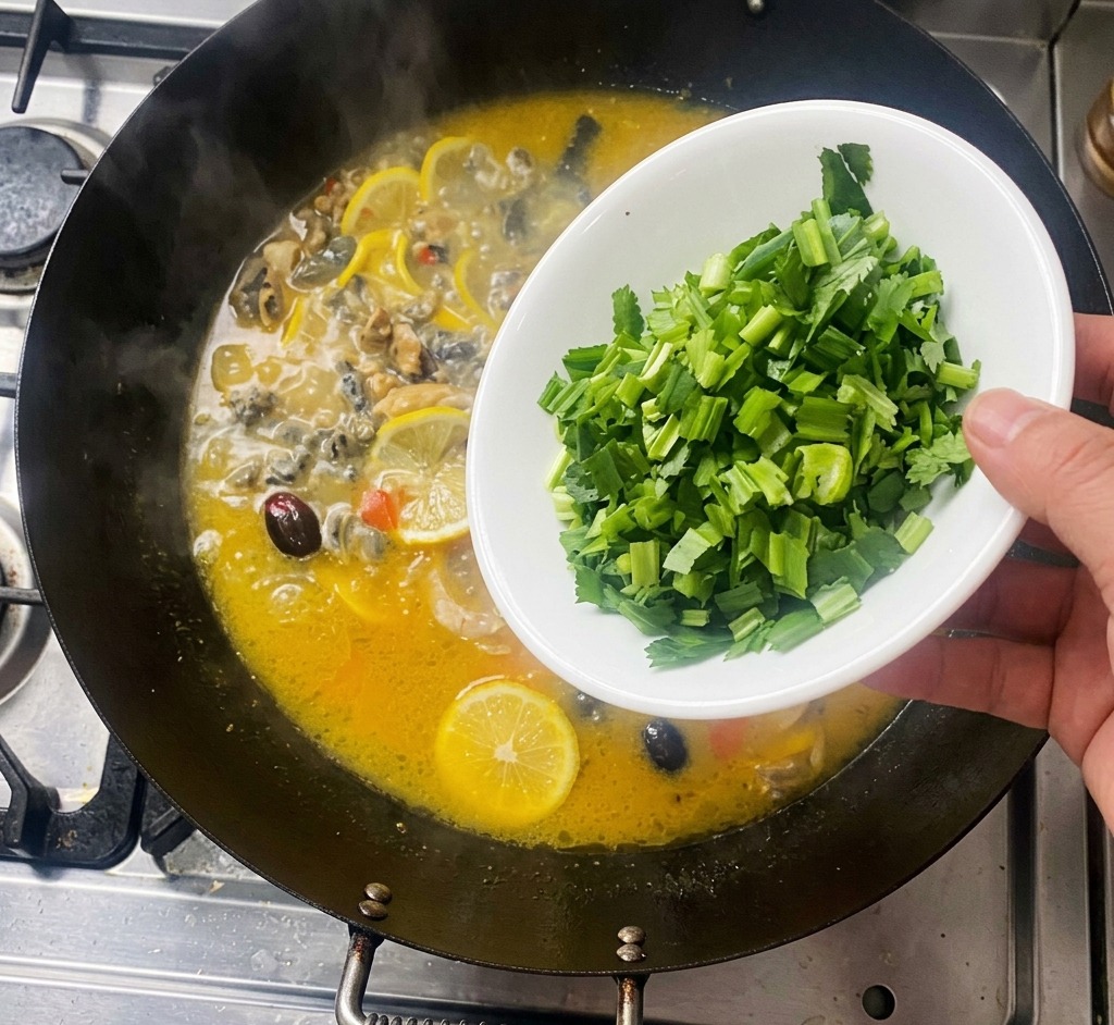 Une main parsemant de la coriandre verte hachée depuis un bol blanc dans un wok fumant contenant le poulet et le citron.