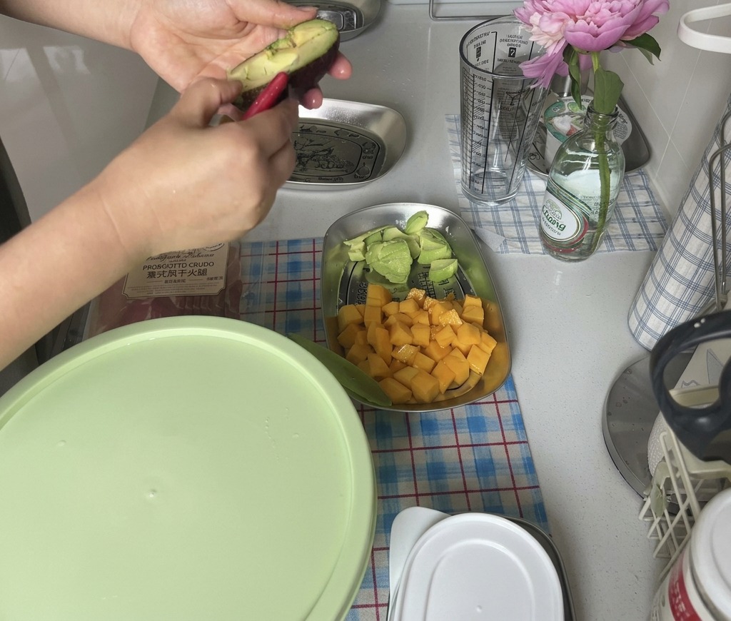 Mains ouvrant en deux un avocat mûr à la peau sombre pour accéder à la chair.