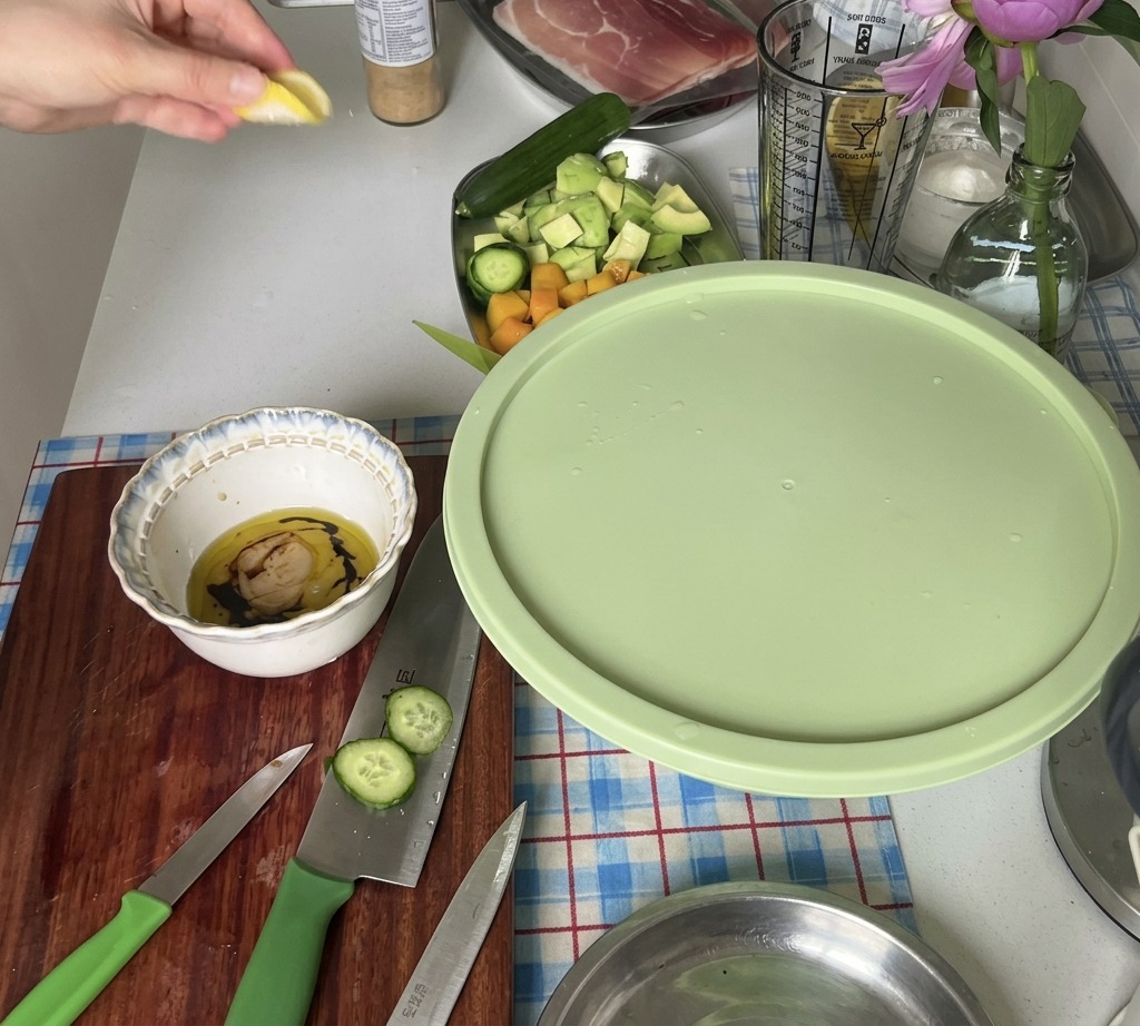Une main pressant le jus dun quartier de citron frais dans un petit bol contenant les ingrédients de la vinaigrette.
