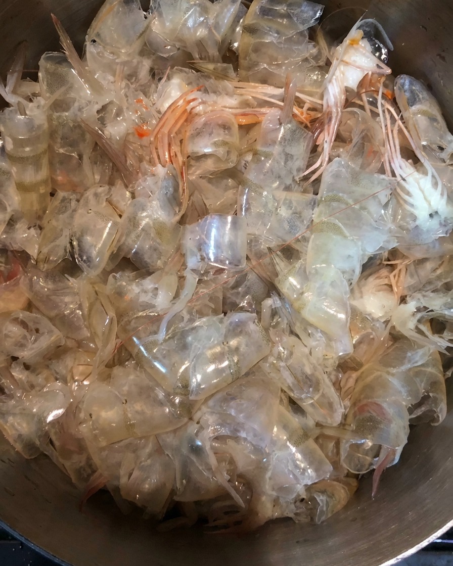 Gros plan sur des carapaces de crevettes fraîches dans une casserole en métal.