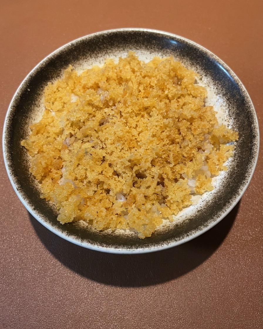 Un bol de riz garni de crevettes frites dorées et croustillantes et dassortiments de légumes comme des aubergines et des champignons shiitake.