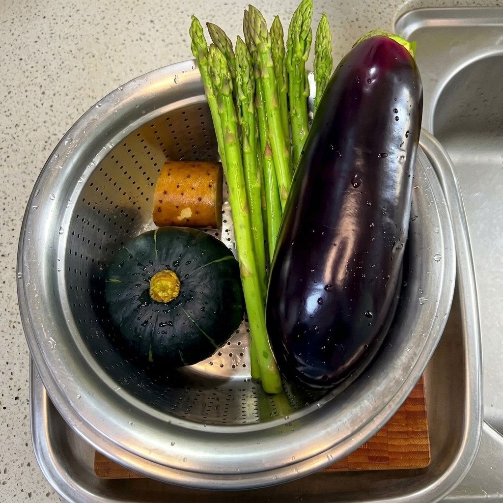 Asperges, aubergine et morceaux de potiron frais lavés et tranchés sur une planche à découper.