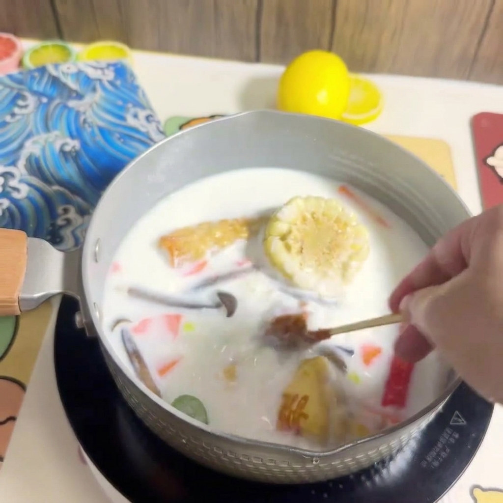 Un bloc de nouilles ramen est plongé dans la casserole de bouillon bouillant.