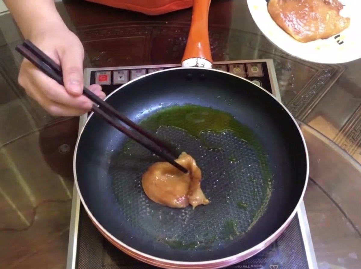 Morceaux de viande marinée brunissant dans une poêle avec un peu dhuile.