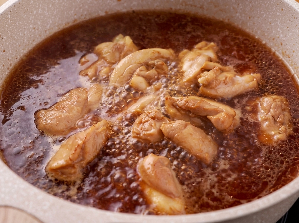De lécume retirée de la surface dun bouillon bouillonnant de poulet et de sauce teriyaki.