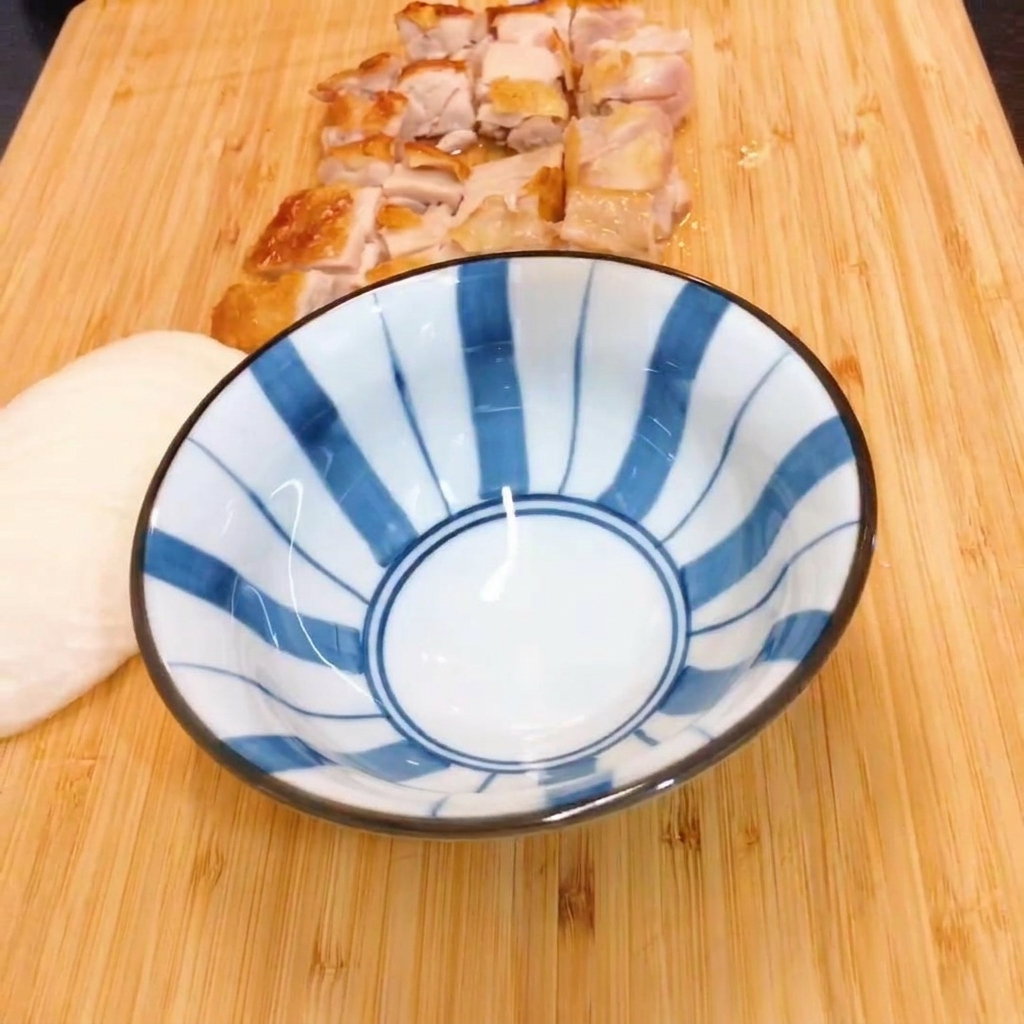 Mirin et sauce soja mélangés dans un bol à rayures bleues et blanches.