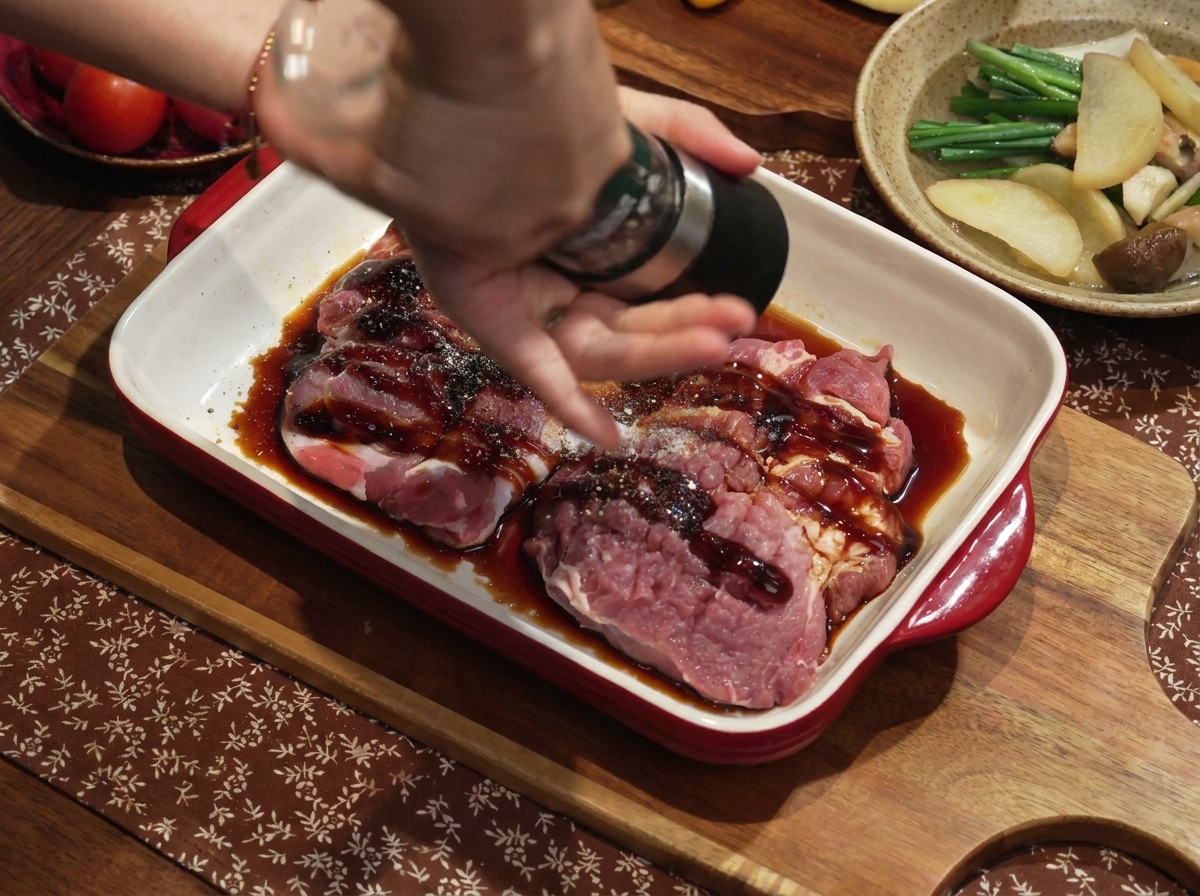 De leau infusée à la ciboule et au gingembre est versée dans un plat contenant le porc mariné.