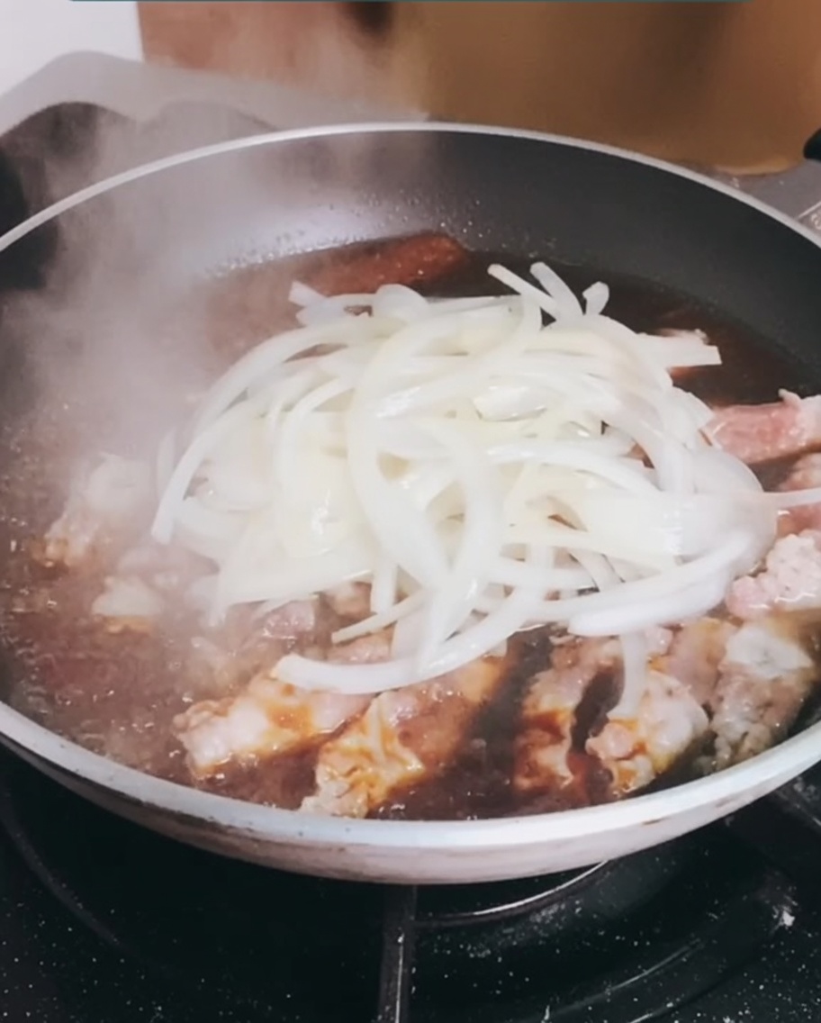 Les oignons cuits sont rajoutés dans la poêle avec le bœuf frémissant.