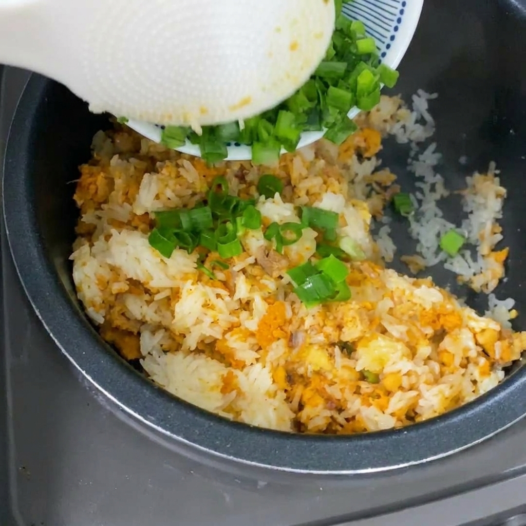 Ciboule fraîche ajoutée sur le riz cuit.