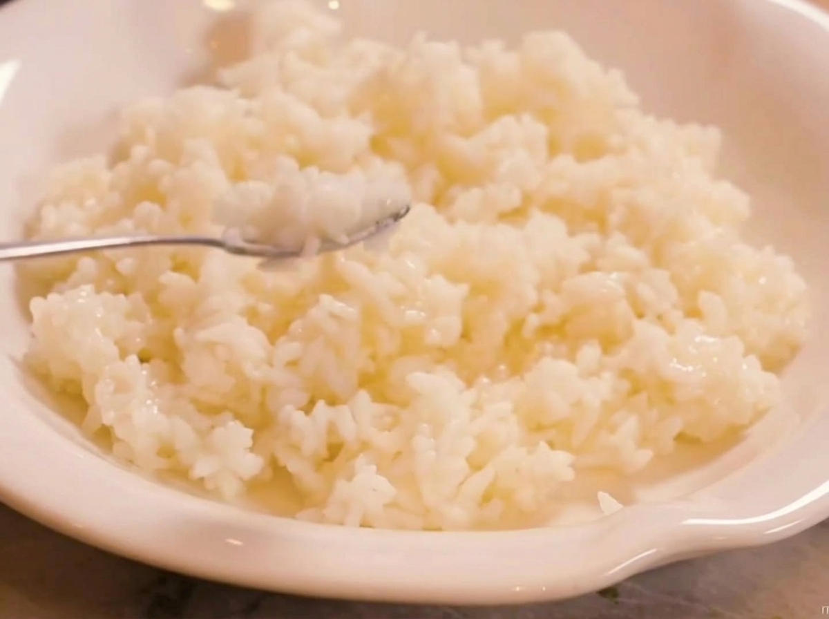 Riz parfumé cuit à la vapeur mélangé au vinaigre à sushi dans un bol blanc.