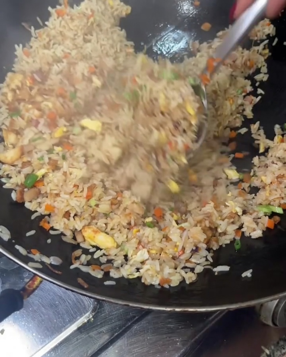 Le riz sauté est mélangé une dernière fois avant dêtre servi.