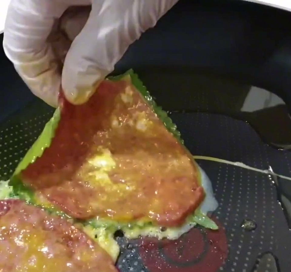 Une galette de bœuf et de feuille de perilla déposée dans une poêle préchauffée avec de lhuile.
