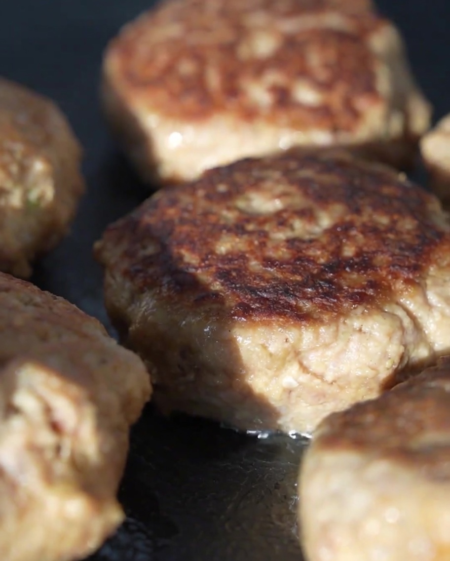 Couvercle en verre couvrant la poêle pour cuire les steaks à la vapeur.