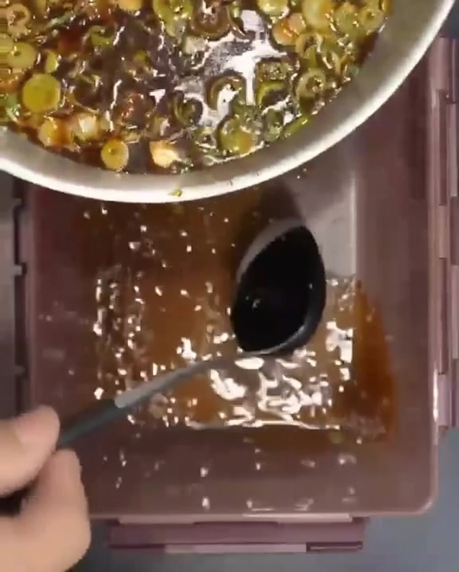 Côtes de bœuf crues disposées dans un récipient, avec la marinade savoureuse versée par-dessus.