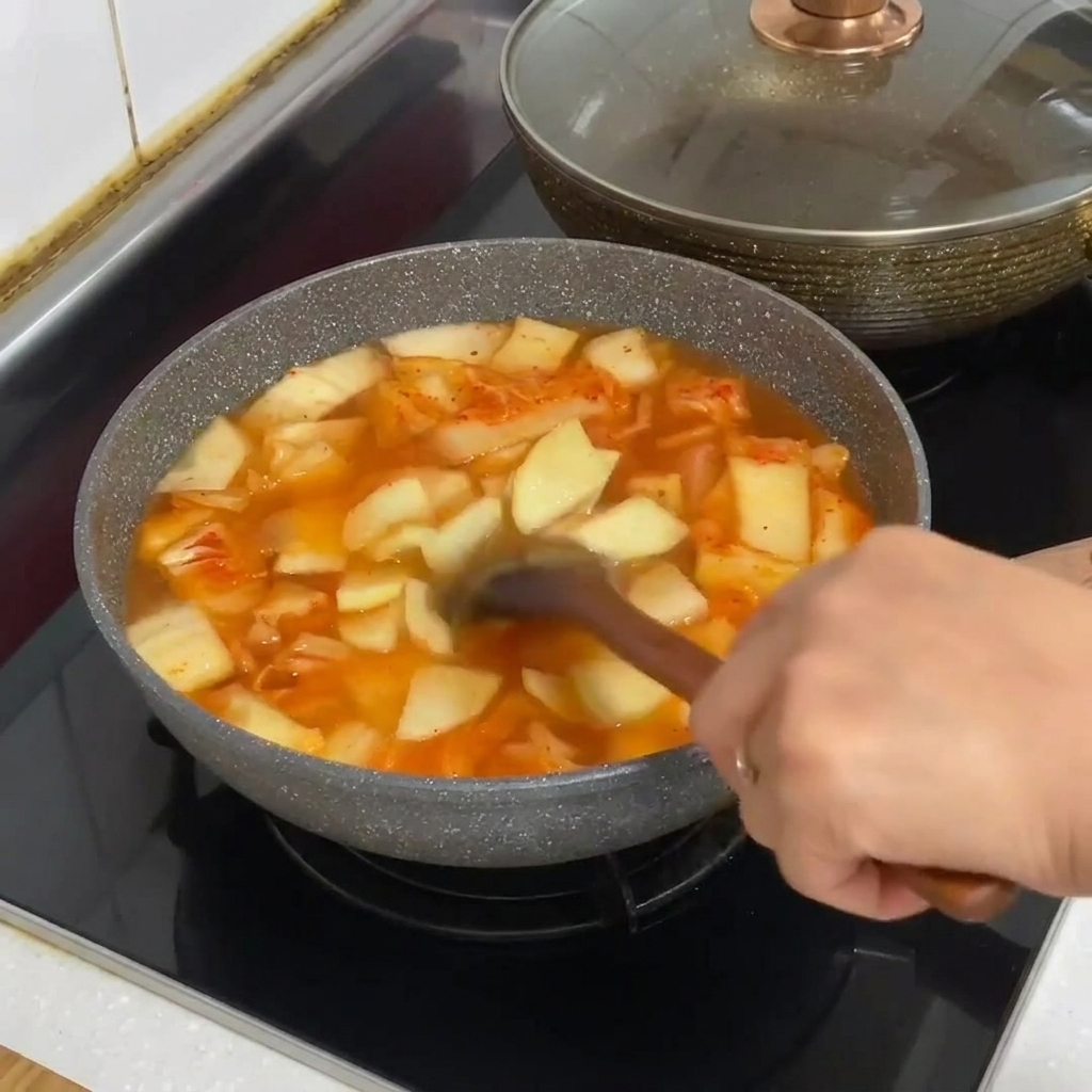 Des nouilles de verre ajoutées dans la casserole de ragoût de kimchi.