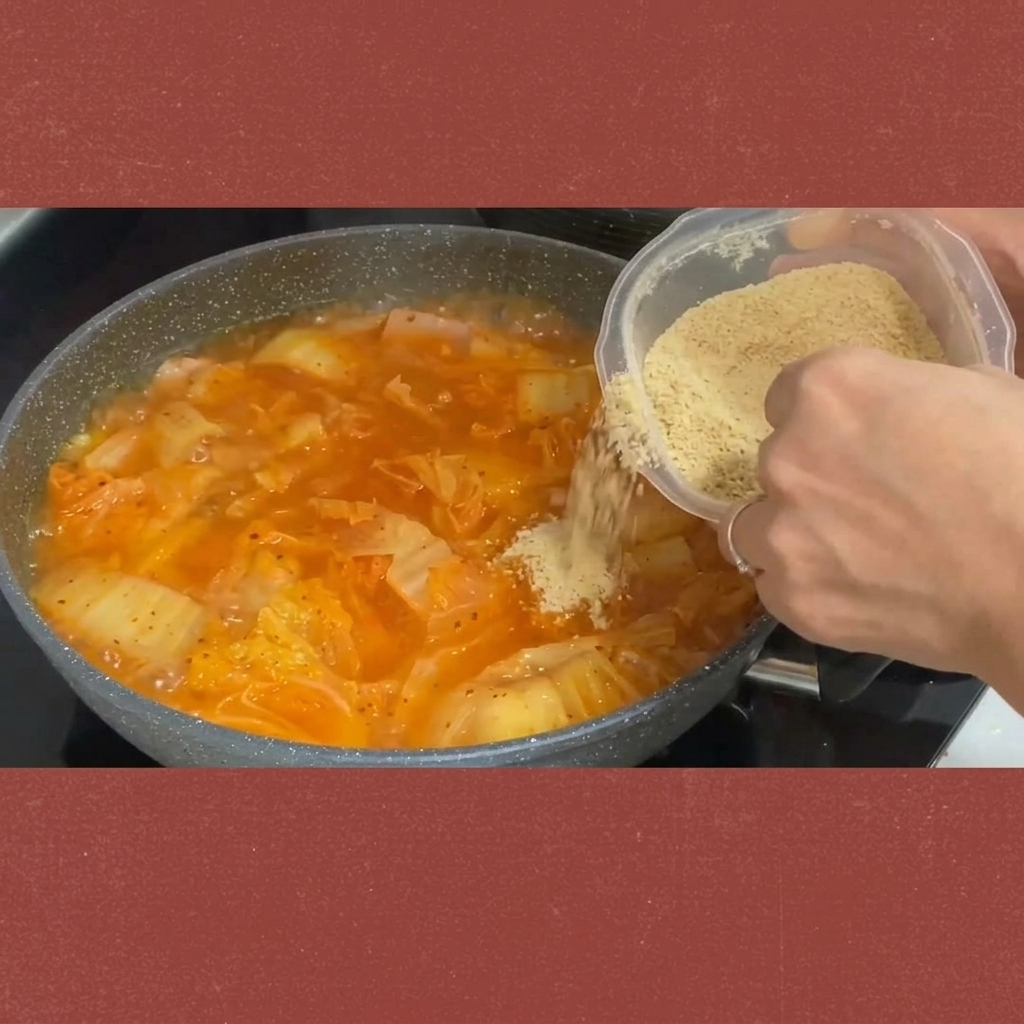 Du sucre saupoudré depuis un récipient dans le ragoût de kimchi mijotant.