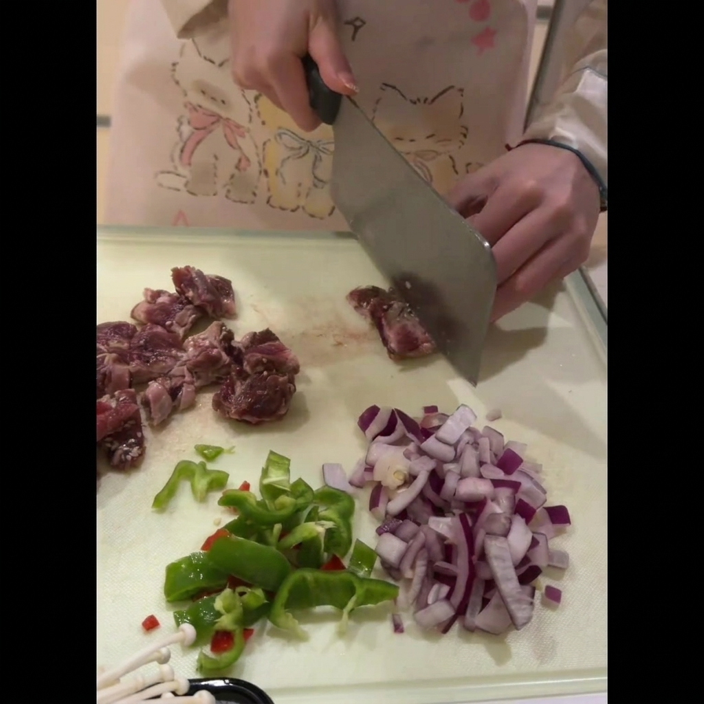 Morceaux de côtes de bœuf soigneusement découpés en petits cubes sur une planche à découper.